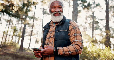 Buy stock photo Hiking, phone and portrait of senior man in forest for wellness, fresh air and online direction. Travel, happy and elderly African person on nature trail for search, health and exercise on smartphone
