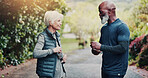 Fitness, park and old couple with water on break for health, wellness or conversation with partner. Bottle, senior man and woman with workout recovery, hydration and rest with interracial people