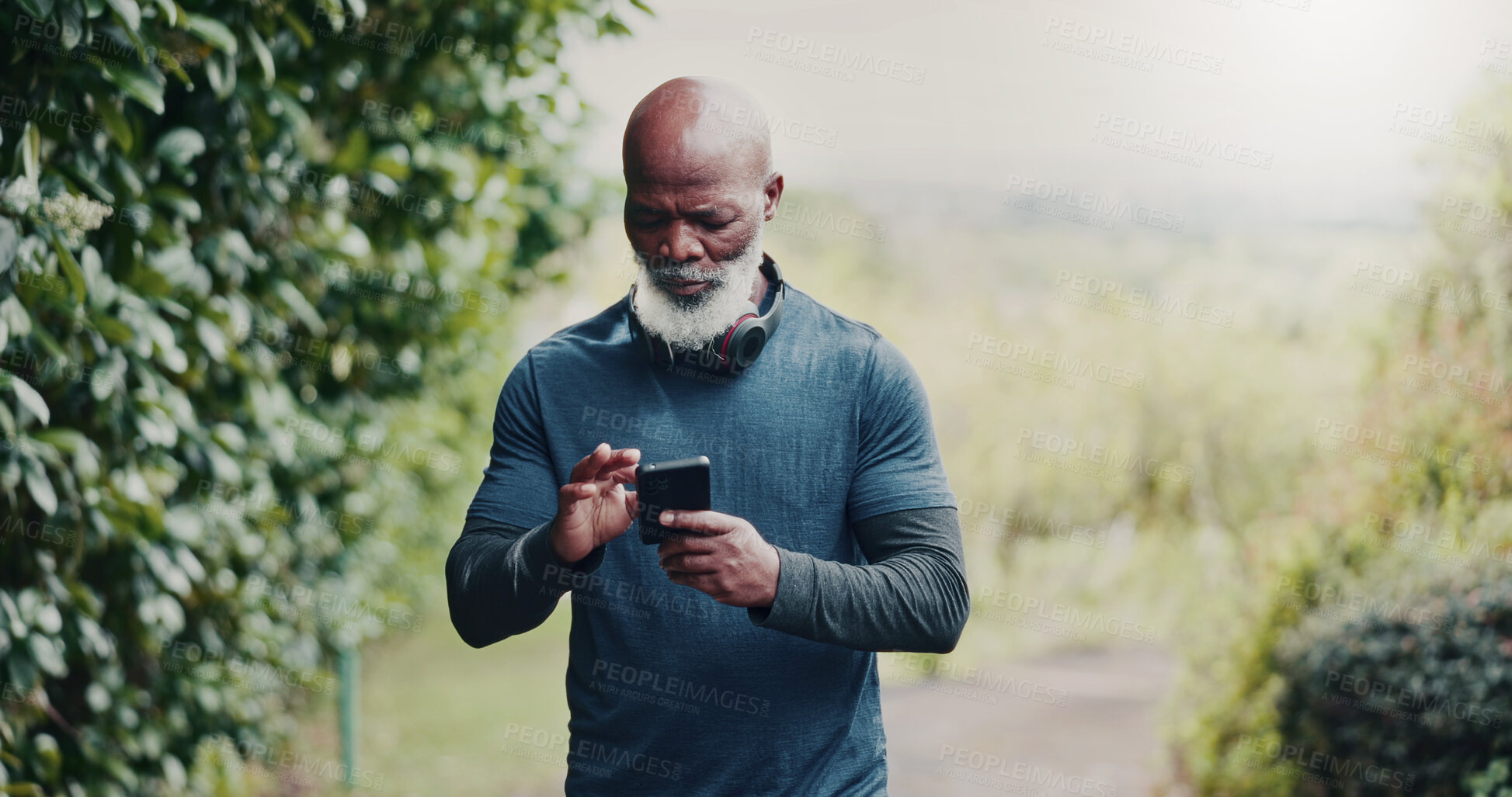 Buy stock photo Outdoor, reading and old man with phone for fitness, running route research or find training playlist. Park, workout app or black person with tech for trail navigation, steps count or music selection