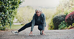 Stretching, fitness and senior woman in nature for workout, training or running with wellness. Health, sports and elderly female person with leg warm up for cardio exercise outdoor at park in morning