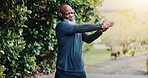 Stretching, headphones and senior black man in park to start workout, exercise and training.  Nature, runner and person with music for warm up, health and wellness for active hobby, sports or fitness