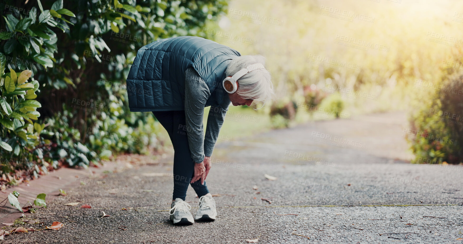 Buy stock photo Senior, woman and ankle injury with headphones on street for workout accident, pressure or strain. Elderly, female person or sore joint with leg pain or discomfort for fibromyalgia or muscle tension