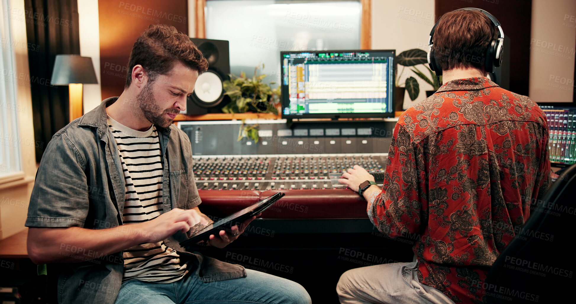 Buy stock photo Sound engineer, tablet and man in recording studio for music, composition or song quality with team. Collaboration, mixing audio or editing with tech for equalizer, creative production and mastering