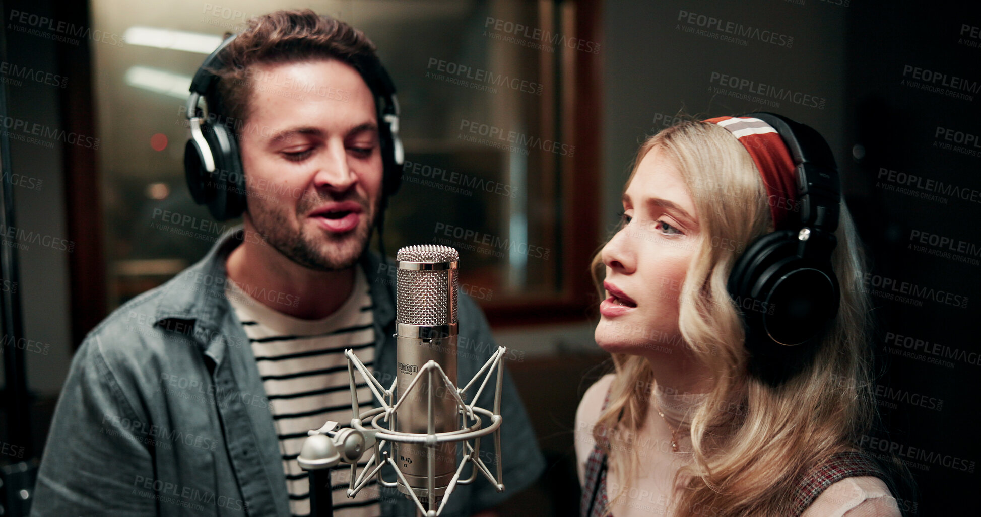 Buy stock photo Singing, microphone and couple with headphones in recording studio, vocal capture and music artists. Tech, man and woman with performance for album feature, teamwork and talent for song production