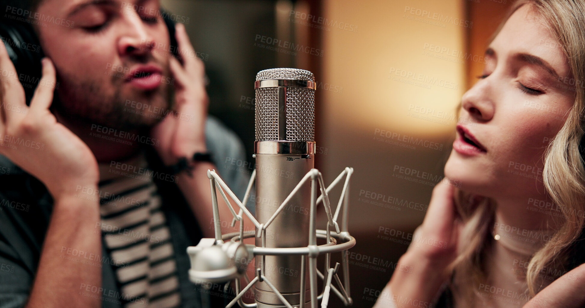 Buy stock photo Sing, microphone and couple with headphones in recording studio, vocal capture and song rehearsal. Tech, music artist and people with performance for album feature, teamwork and talent for production