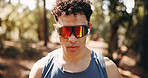 Serious, athlete and man with earphones in nature, space and plan for exercise on break and fitness. Outdoor, runner and person with tech for audio, streaming and workout reflection for wellness