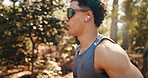Running, fitness and man with earphones in nature for training, exercise and workout for cardio. Sports, athlete and person on outdoor trail for active hobby, endurance and wellness with sunglasses