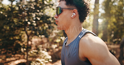 Buy stock photo Running, fitness and man with earphones in nature for training, exercise and workout for cardio. Sports, athlete and person on outdoor trail for active hobby, endurance and wellness with music
