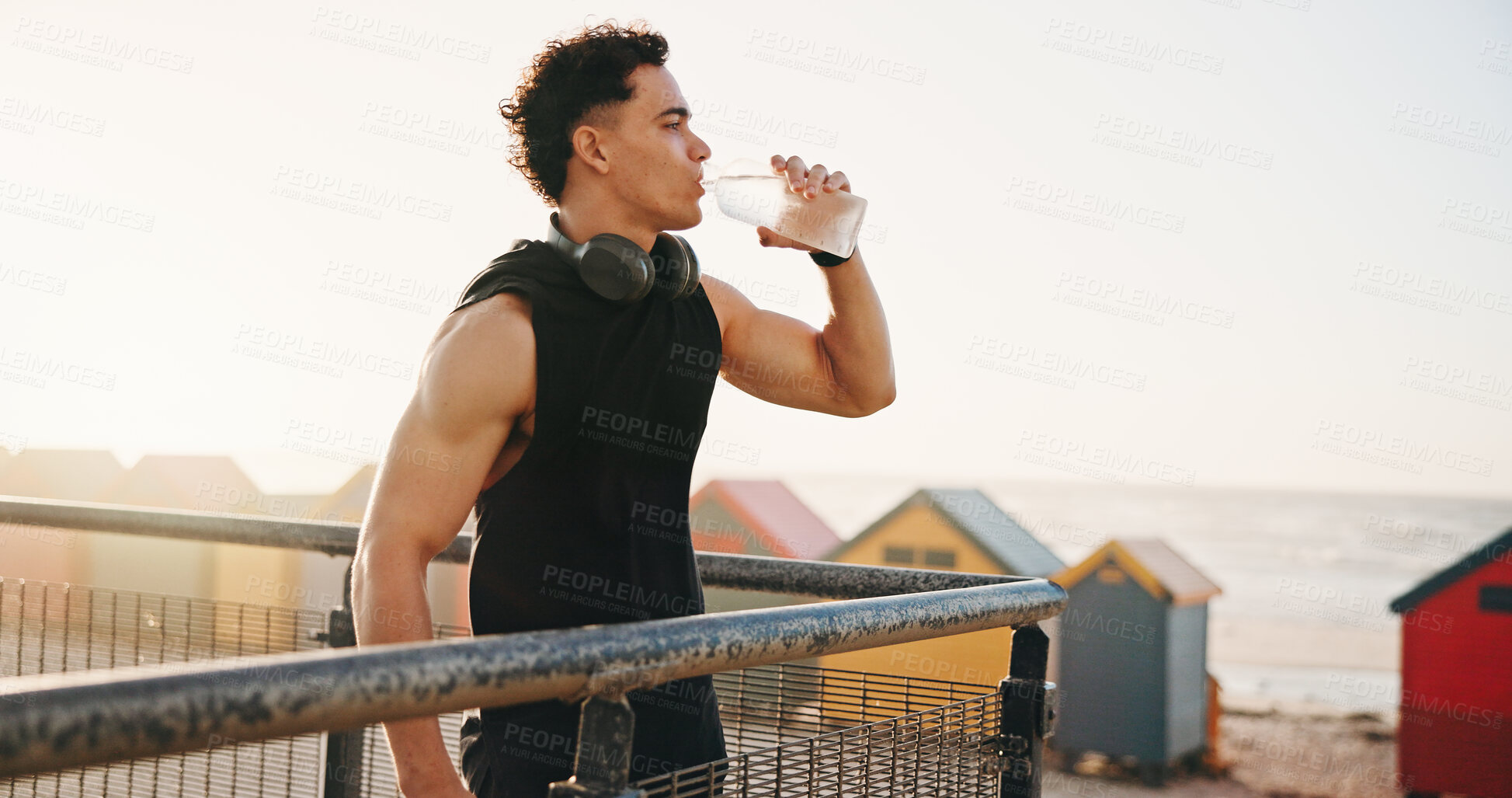 Buy stock photo Beach, fitness and man with water on break, reflection and drinking liquid after training in nature. Outdoor, space and person with bottle for wellness, exercise and cool down with mineral hydration