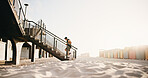 Running, fitness and man on stairs by beach for exercise, workout and training for cardio, health and wellness. Athlete, sports and person with active hobby for steps, endurance and runner challenge