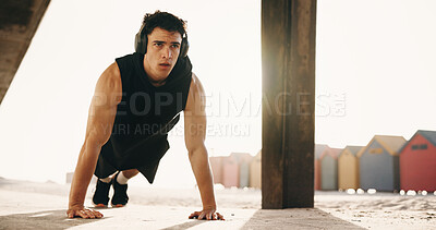 Buy stock photo Fitness, pushups and man with headphones on beach, athlete or serious for health with music playlist. Outdoor, endurance and person with tech for audio, training and exercise routine for wellness