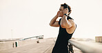Thinking, athlete and happy man with headphones on bridge, remember and plan for workout and fitness. Outdoor, runner and person with tech for audio, space or exercise reflection for wellness in city