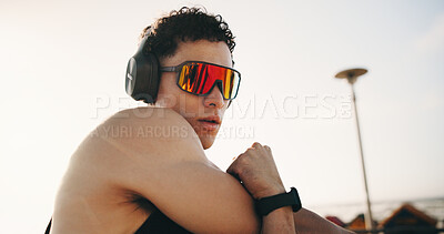 Buy stock photo Stretching, fitness and man with sunglasses outdoor for exercise, workout and training for mobility, cardio and health. City, arms and person with warm up for wellness, flexibility or listen to music