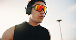 Athlete, breathing and man with headphones after workout, remember or listening to song for fitness. Outdoor, space and person with tech for audio, low angle and exercise reflection for wellness