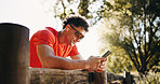 Fitness, earphones and man in nature with phone for social media after training, exercise and workout. Sports, athlete and person on smartphone for health app, internet and streaming music outdoor