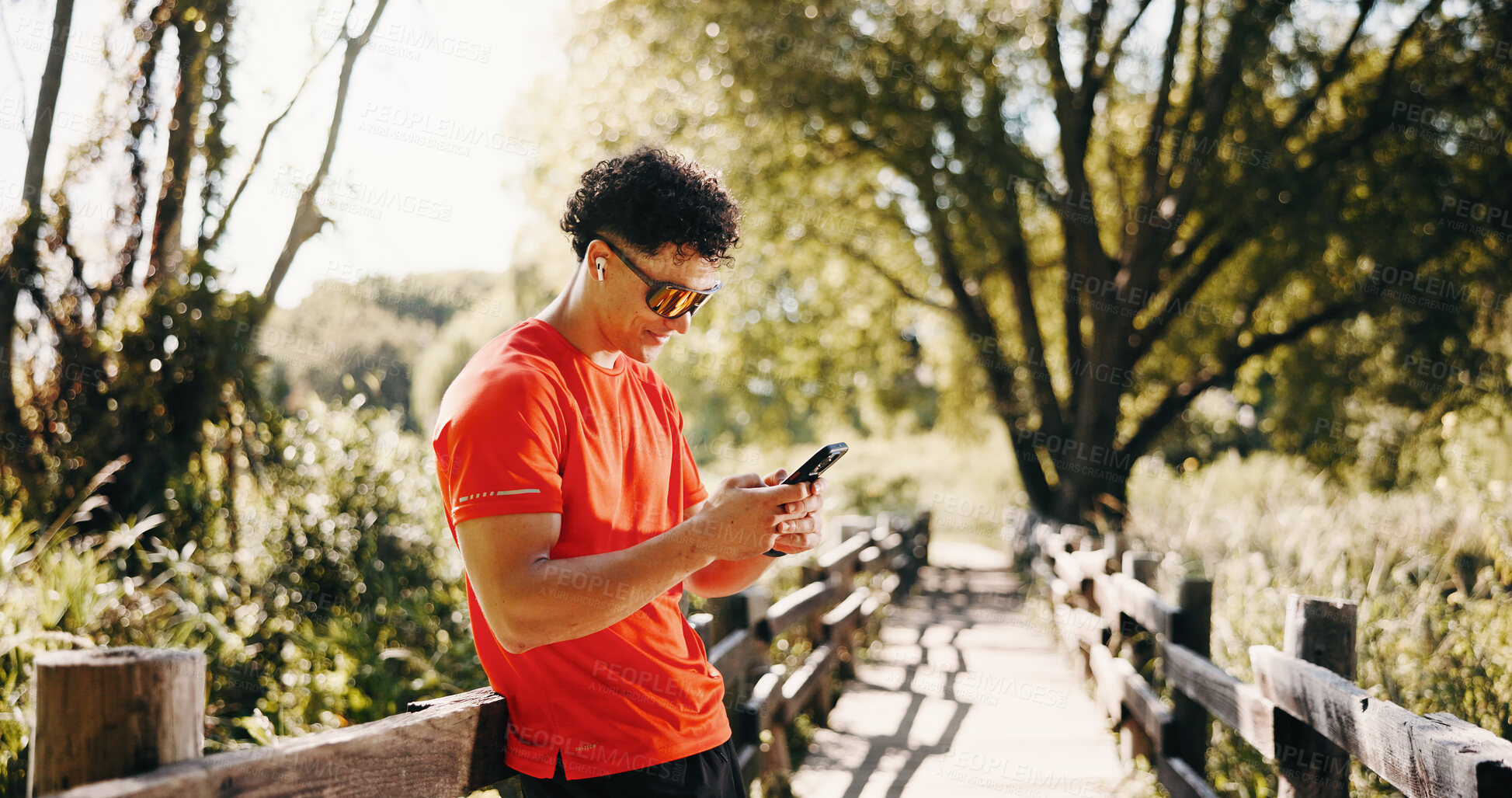 Buy stock photo Exercise, earphones and man in nature with phone for social media after training, fitness and break. Sports, athlete and person on smartphone for health app, internet and streaming music outdoor