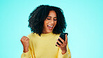 Winner, phone and excited in studio for lottery, competition and results notification. Fist pump, woman and celebration with tech for good news, promotion and giveaway or success on blue background