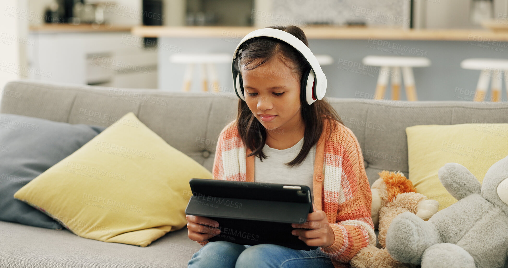 Buy stock photo Child, tablet and watching movie on sofa with headphones, website and browsing online for cartoon. Girl, relax and streaming show in home with audio tech, digital app or film series for entertainment