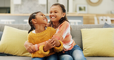 Buy stock photo Happy, laugh and sisters hug on sofa for bonding, playful relationship and affection in home. Family, children and girls with humor, silly and embrace for love, support and together in living room