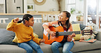 Girl, guitar and happy in home with sister for dancing, music and bonding with love on sofa in lounge. Kids, smile and play song with instrument, sound and creativity in living room at family house