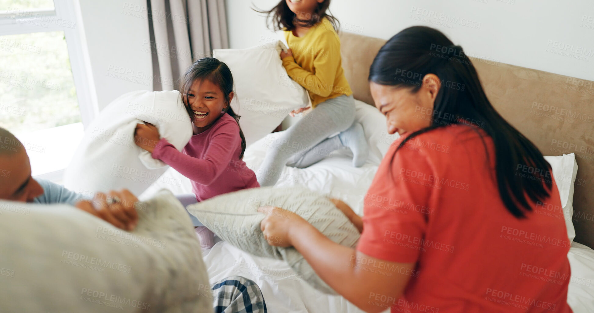 Buy stock photo Pillow fight, funny and family in bedroom, girls and bonding together with happiness. Kids, mother and father in home, laughing and excited for fun game, playing and parent with break and morning