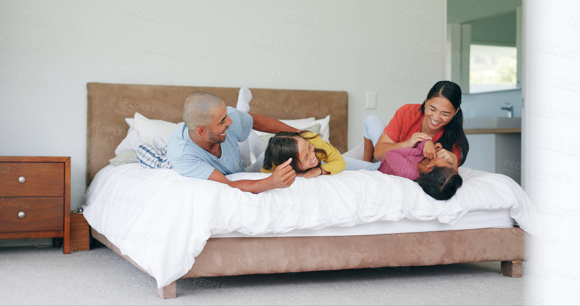Buy stock photo Tickle, parents and kids relax on bed, bonding together and laughing with care in morning at house. Children, mother and father play in bedroom at home with funny game, family connection and love