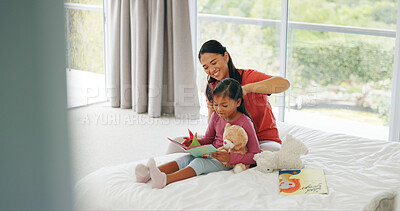 Buy stock photo Brushing hair, mother and reading with daughter in bedroom of home for education or grooming. Book, family and haircare of girl child with single parent woman on bed for bonding, learning or study