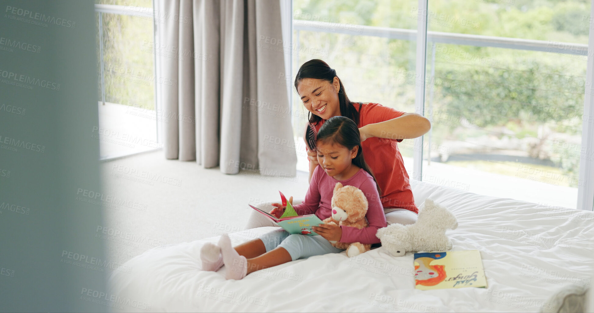Buy stock photo Brushing hair, mother and reading with daughter in bedroom of home for education or grooming. Book, family and haircare of girl child with single parent woman on bed for bonding, learning or study