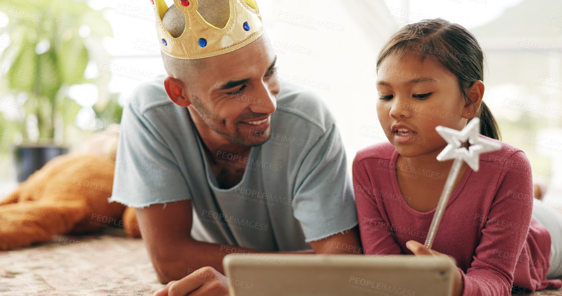 Buy stock photo Education, smile and tablet of daughter with dad on living room floor for family or fantasy story. App, crown and wand of girl child with single parent man in apartment for learning or streaming