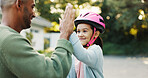Bike, learning and father with girl, high five for support and child development with smile. Parent, outdoor and dad with daughter, gesture for growth and teaching with celebration for goal or safety