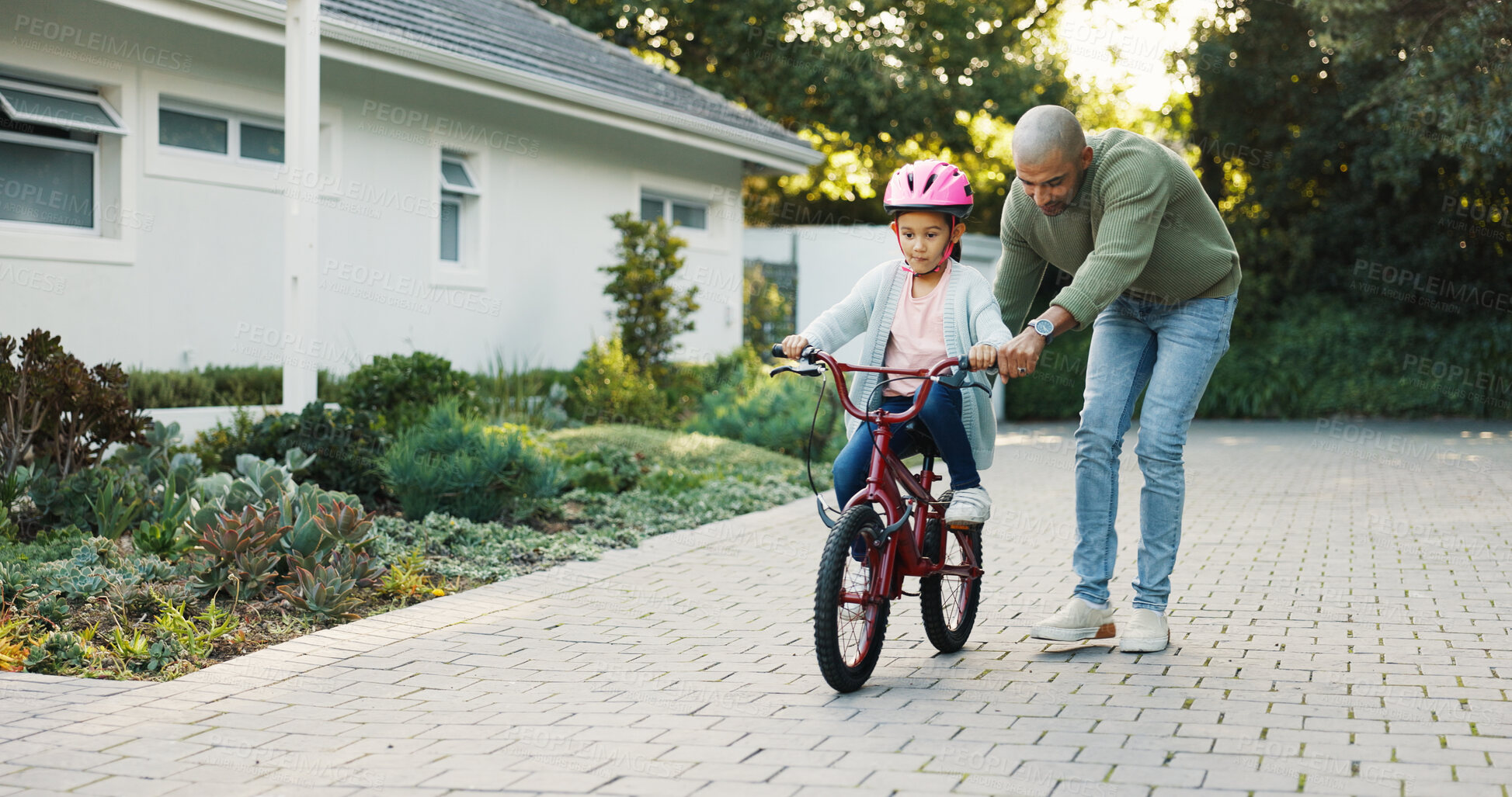 Buy stock photo Bicycle, development and father teaching daughter how to balance or ride outdoor in front of home. Guide, helping and single parent of girl child in driveway for cycling activity, growth or learning