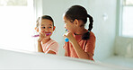 Sisters, girls and brushing teeth by mirror in bathroom, oral hygiene and morning routine for bonding. Reflection, grooming and happy children with toothbrush for dental care, cleaning mouth and home