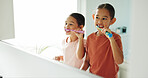 Children, girls and brushing teeth by mirror in bathroom, oral hygiene and morning routine for wellness. Reflection, grooming and happy sisters with toothbrush for dental care, cleaning mouth or home