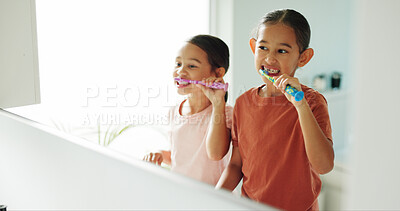 Buy stock photo Children, girls and brushing teeth by mirror in bathroom, oral hygiene and morning routine for wellness. Reflection, grooming and happy sisters with toothbrush for dental care, cleaning mouth or home