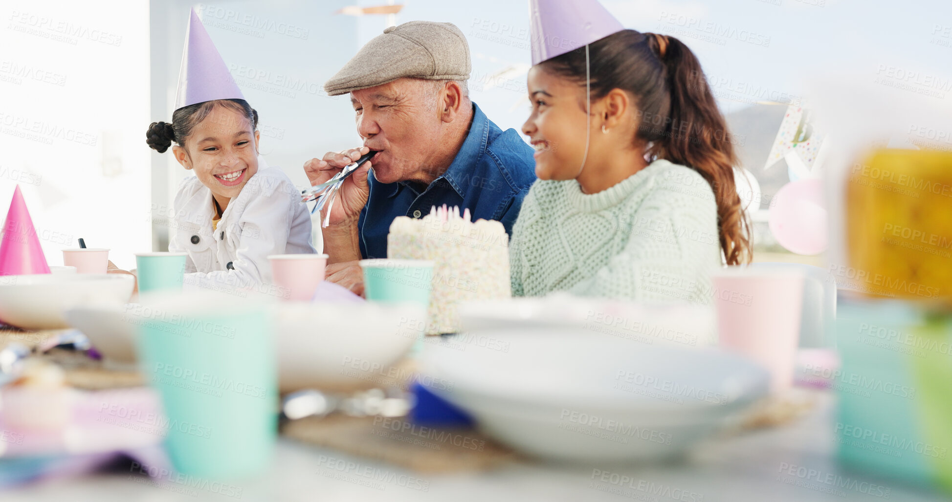 Buy stock photo Grandfather, children and horn for birthday celebration, bonding together and care with generations. Grandparent, happy girls and blower at party with cake, special day and young kids in family home