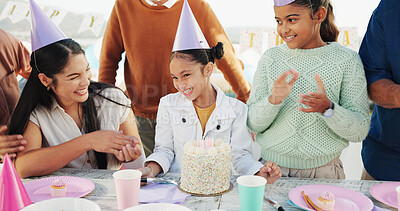 Buy stock photo Happy child, family and birthday with party hat or cake for outdoor celebration together at table. Excited, group or laughing with smile, balloons or milestone for year, wishing or social gathering