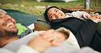 Happy woman, relax and man on picnic blanket for camping with funny story, chat or conversation. People, couple and getaway in nature with bag, bonding and vacation with relationship in countryside
