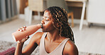 Yoga, woman and drinking water in apartment with break, wellness or natural detox for holistic health. Thirsty, black person and exercise rest in home with bottle, nutrients or beverage for hydration