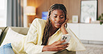 Relax, reading and phone with black woman on sofa in home for communication, social media and smile. Contact, online chat and connection with person and mobile in living room of apartment for app