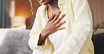Hands, discomfort and woman with chest pain on sofa for heart attack symptoms, hypertension and risk. Health, female person and artery pressure in home for cardiac arrest, medical emergency or angina