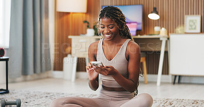 Buy stock photo Smile, fitness and phone with black woman in home for communication, health app and break. Social media, yoga pose search and connection with person and mobile in living room of house for wellness