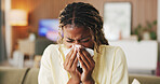 Sneeze, tissue and black woman in home, sick and cold with fever in living room. Apartment, illness and African person on couch, allergy and recover for infection, blowing nose and influenza symptoms