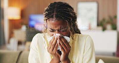 Buy stock photo Sneeze, tissue and black woman in home, sick and cold with fever in living room. Apartment, illness and African person on couch, allergy and recover for infection, blowing nose and influenza symptoms