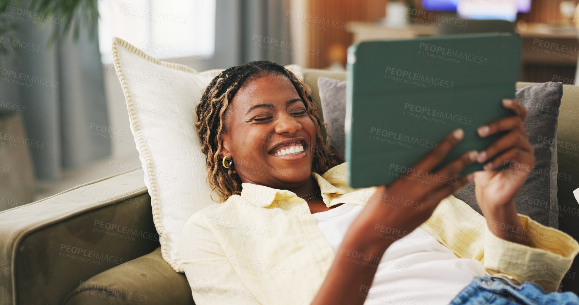 Buy stock photo Happy, home and black woman on sofa, tablet for social media and reaction for post. Apartment, tech and African person on couch, connection for online announcement, internet and smile for text