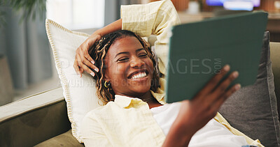 Buy stock photo Funny, home and black woman on sofa, tablet for social media and reaction for post. Happy, tech and African person on couch, connection for online announcement and laughing for comedy video or joke