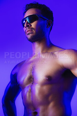 Buy stock photo Man, sunglasses and topless in studio with muscle, bodybuilding and aesthetic on purple background. Person, shades and fitness with neon, shirtless and transformation for wellness with healthy body