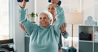 Buy stock photo Old woman, physiotherapist and smile with dumbbells at clinic for exercise, support or recovery for injury. People, healthcare professional and happy with help, strength training and rehabilitation