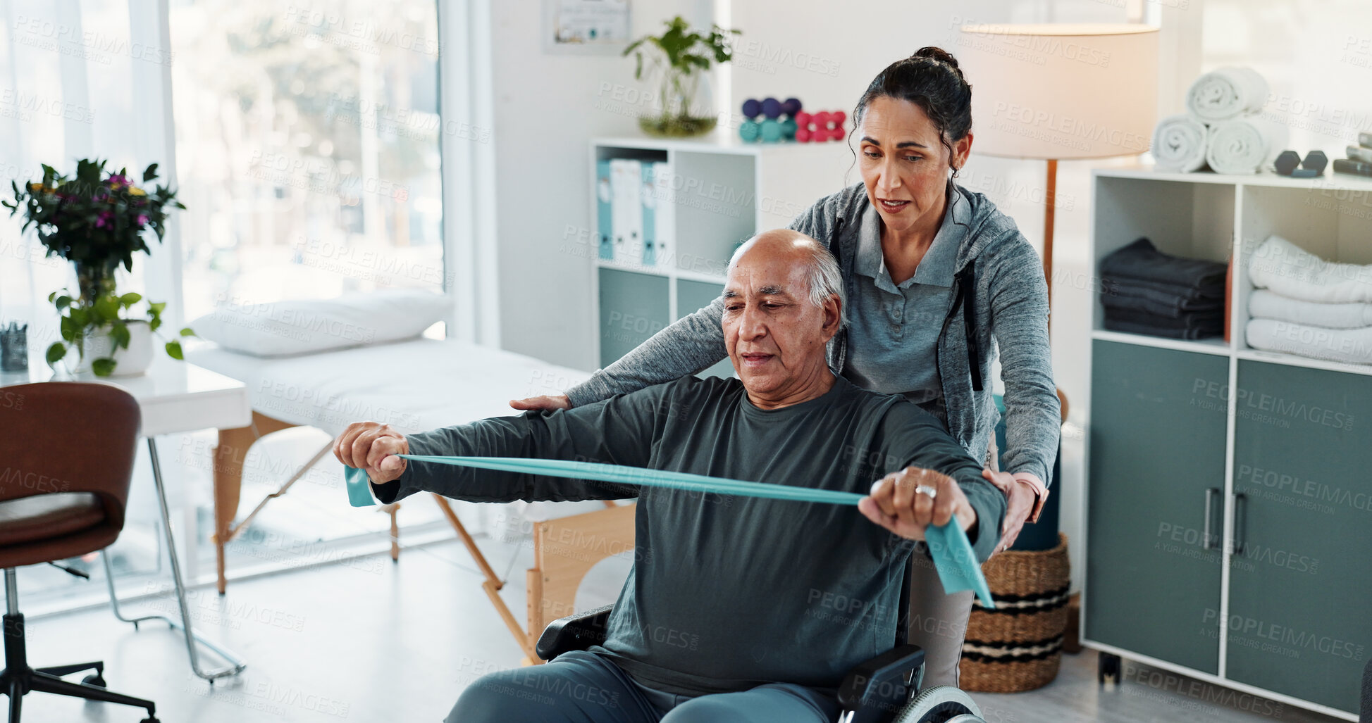 Buy stock photo Man, physiotherapist and stretching with discussion for progress, medical service or recovery. People, mature patient with a disability and resistance band for injury, rehabilitation and clinic help