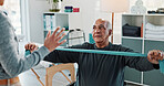 Man, physiotherapist and resistance band with discussion for progress, medical service and recovery. People, mature patient and woman with exercise for injury, rehabilitation and gear at clinic