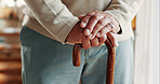 Elderly, person and hands with walking stick in home for mobility, old age assistance or aid. Closeup, senior or support with wooden cane for stability, safety or help in retirement or nursing house